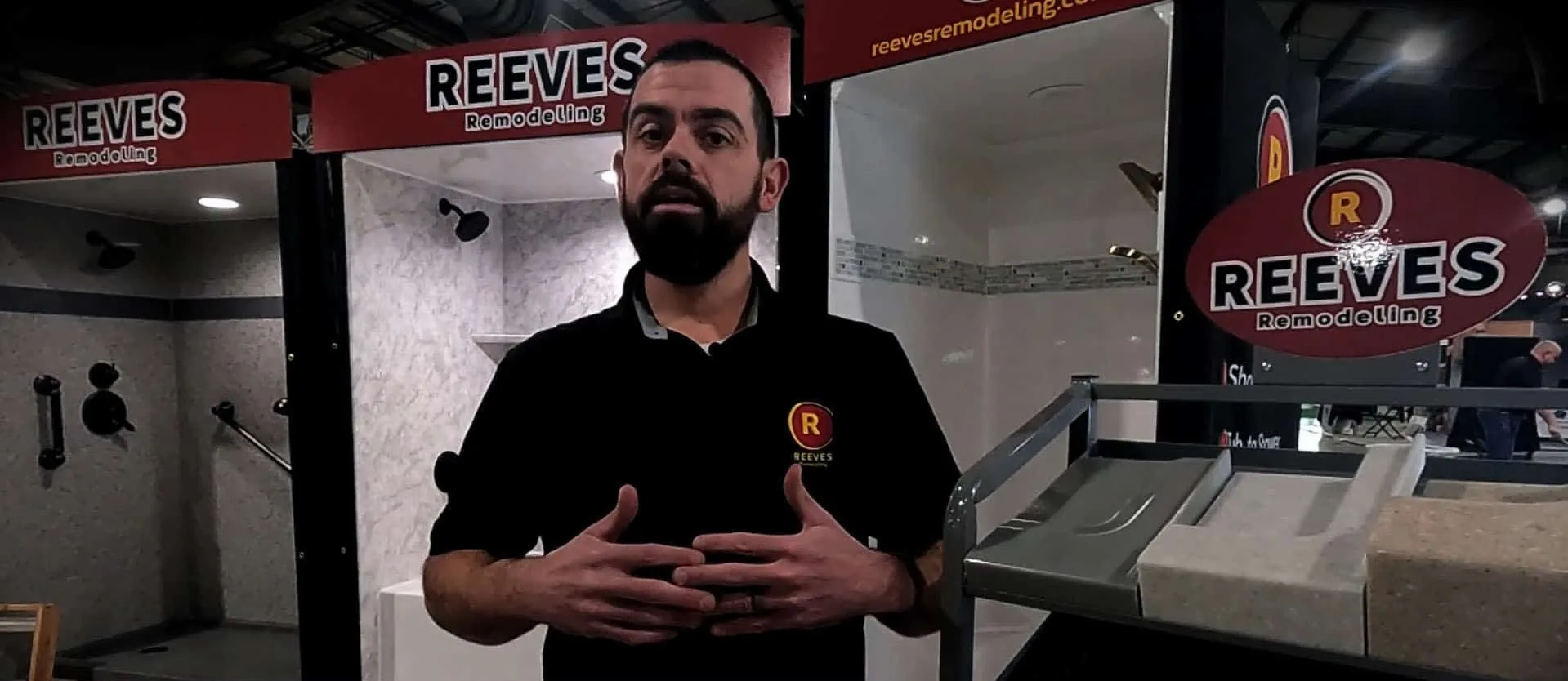 Stephen Reeves in the Reeves Remodeling showroom in Tulsa, standing between two solid surface shower displays