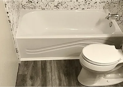 A white bathtub with a stainless grab bar above it